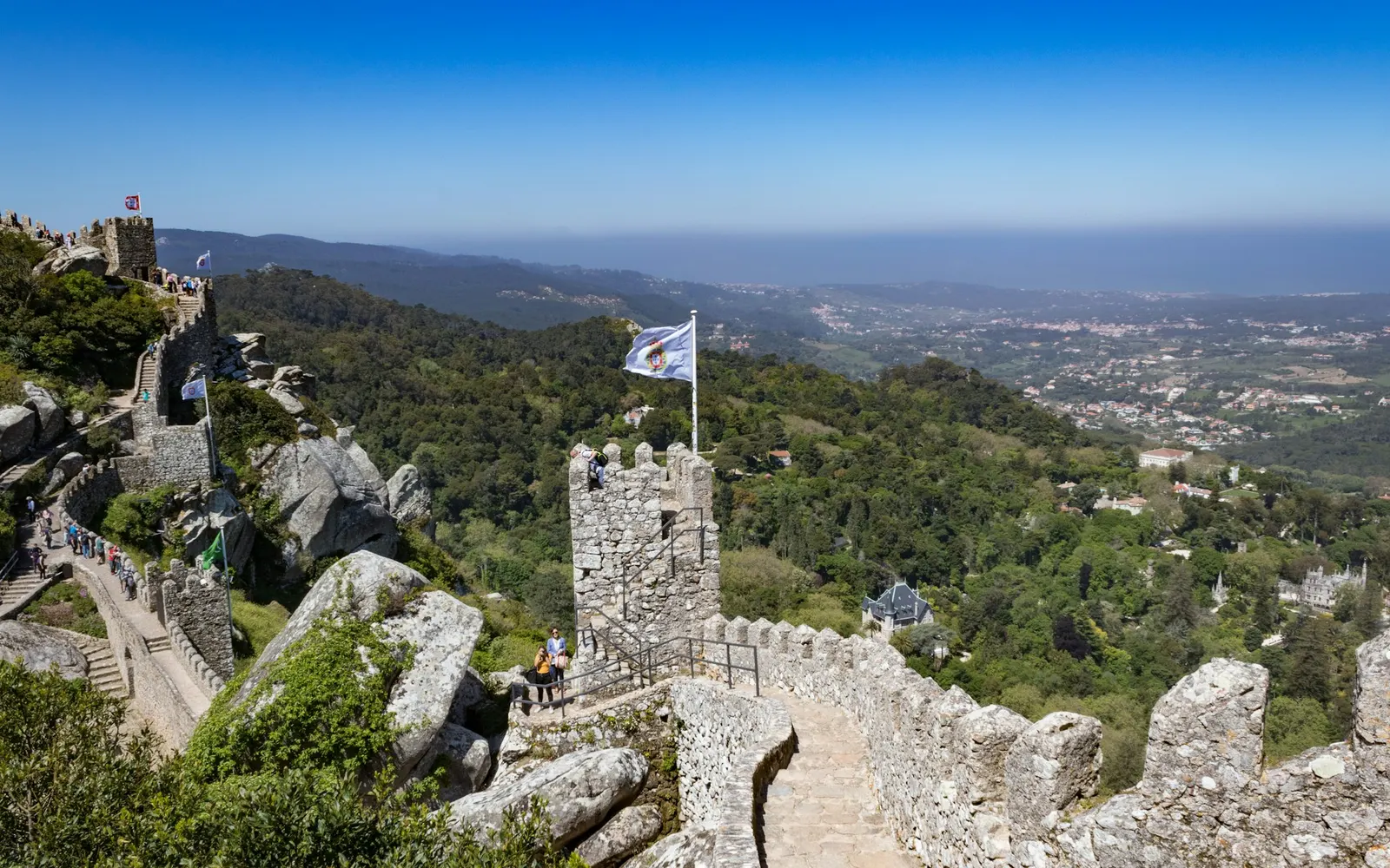 The Royal Tower of the Castelo dos Mouros with flags flying and the Sintra valley below