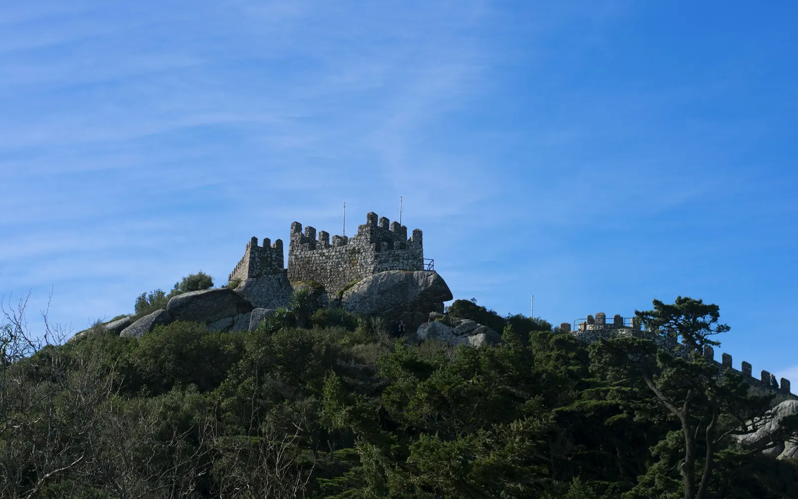 A crenellated tower of the Moorish Castle against a blue sky